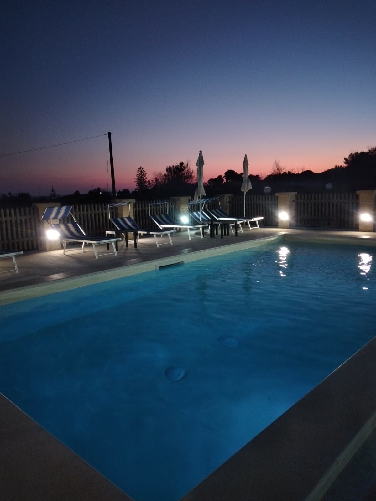 La piscina illuminata al tramonto