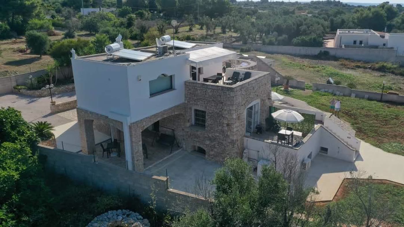 La villa in pietra vista dall'alto, con il portico e il giardino