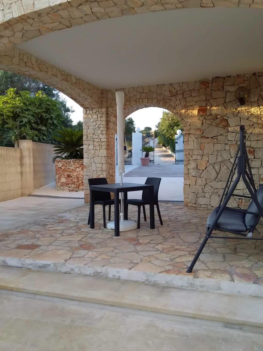 Il portico ad archi in pietra con tavolo e dondolo