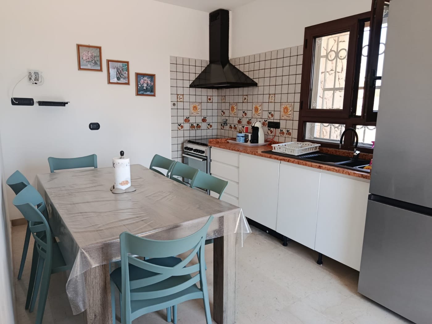 La sala da pranzo con il tavolo grande e le sedie verde acqua